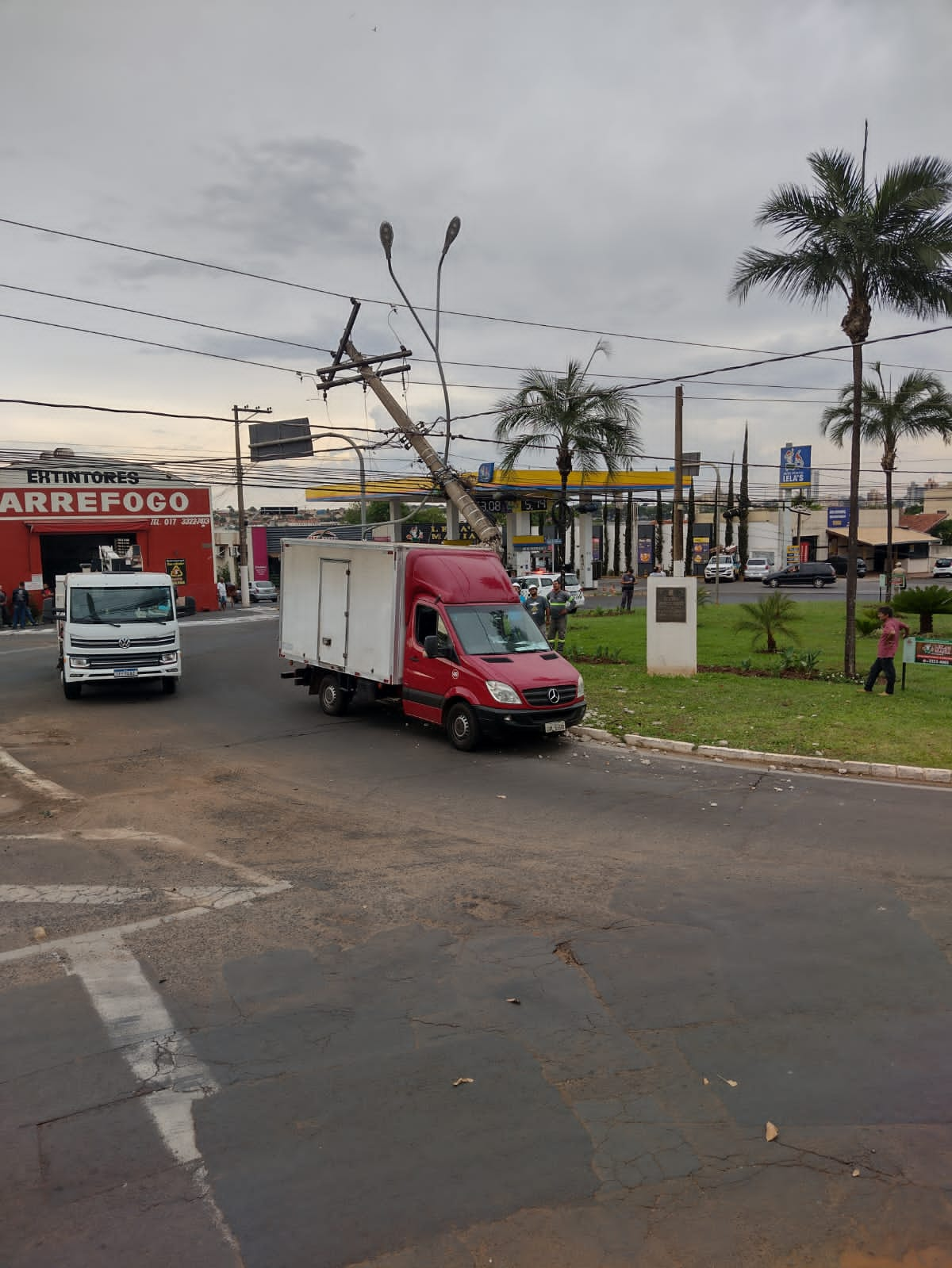 Caminhão colide contra poste em rotatória